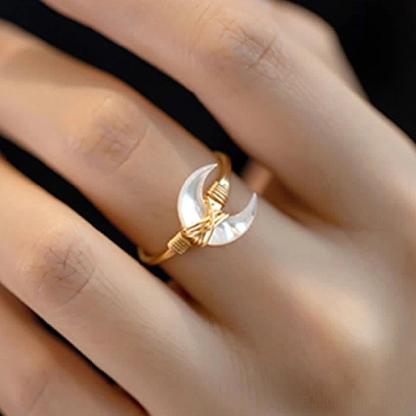White tridacna stone moon blessing ring on finger, close-up showing twisted 14K gold wire wrap and comfortable wear