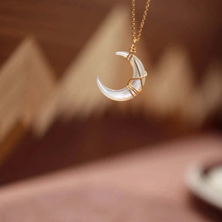 Tridacna stone crescent moon necklace pendant front overhead hanging position showing crossed gold wire wrapping technique and chain attachment