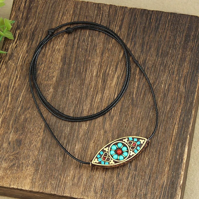Handcrafted turquoise Buddhist necklace pendant with coiled wax rope and full inlay design on dark wood
