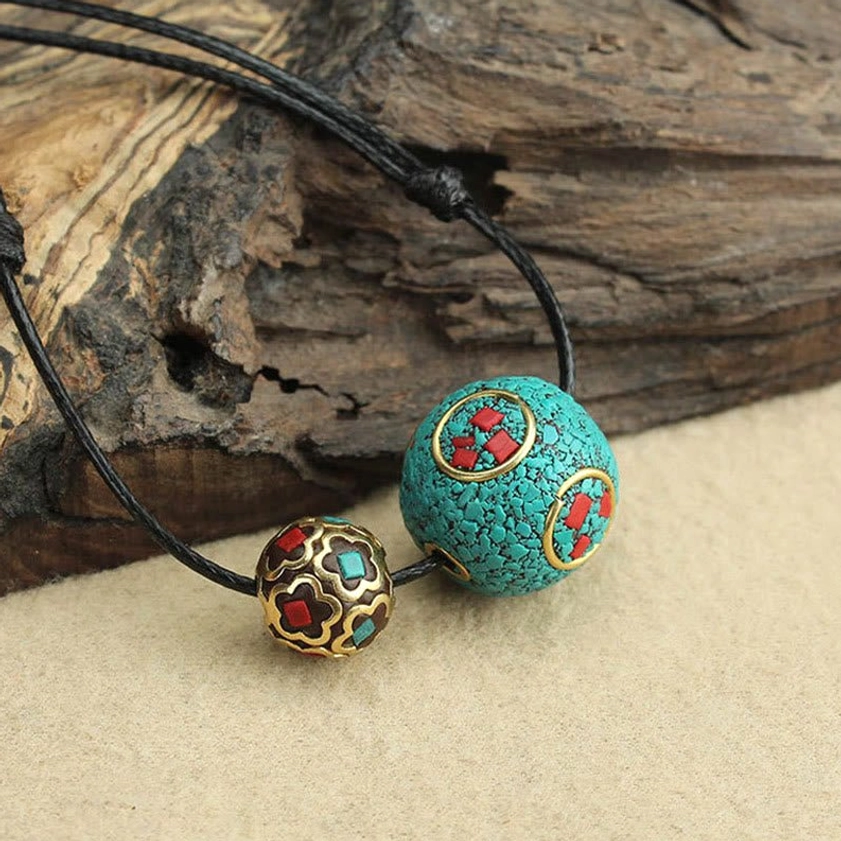 Authentic turquoise double bead Buddhist necklace positioned on weathered wood and beige surface, artisan crafted