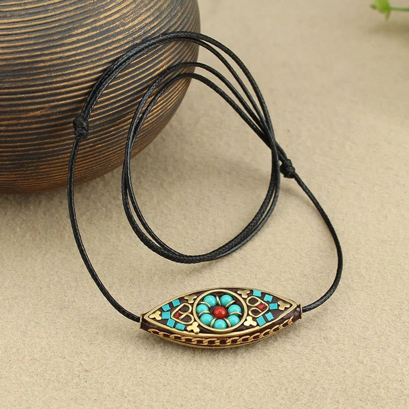 Handmade turquoise Buddhist necklace pendant with multi-layer black wax cord styled with vintage wooden jar prop