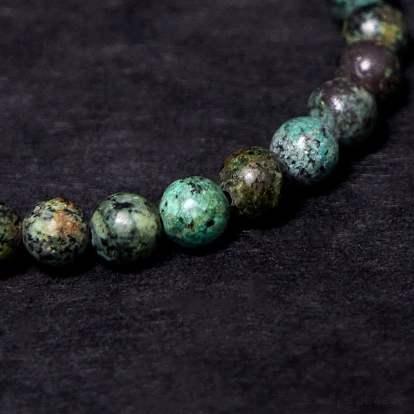 Extreme close-up detail of natural variegated turquoise stones and vintage copper beads on elastic bracelet