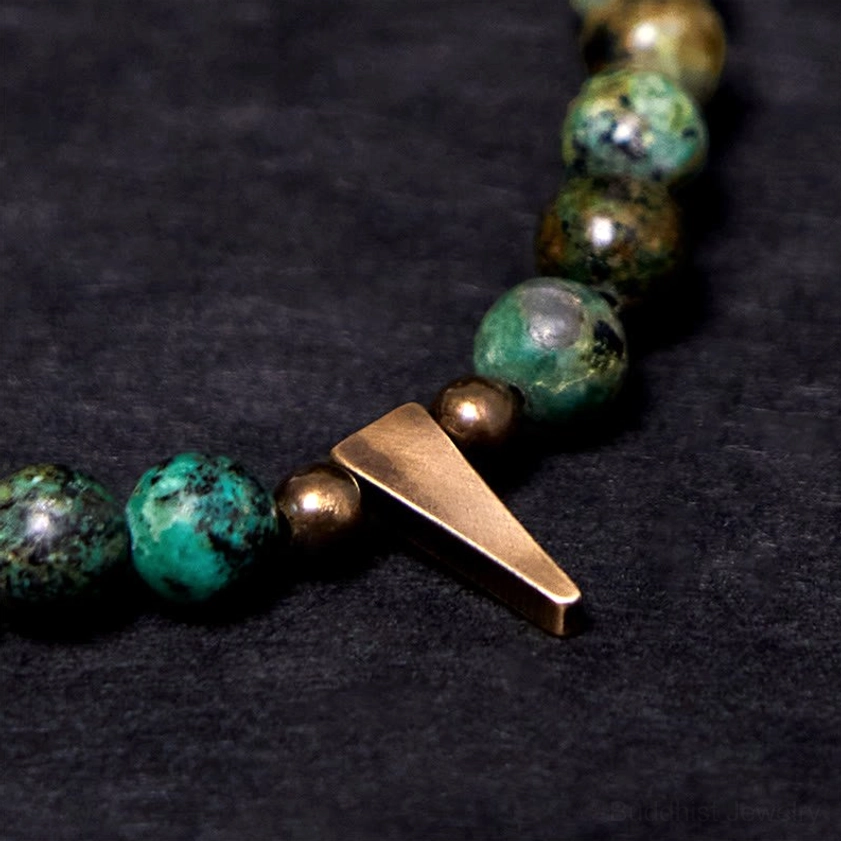 Close-up macro view of turquoise beads, copper spike charm and matte copper spacer beads