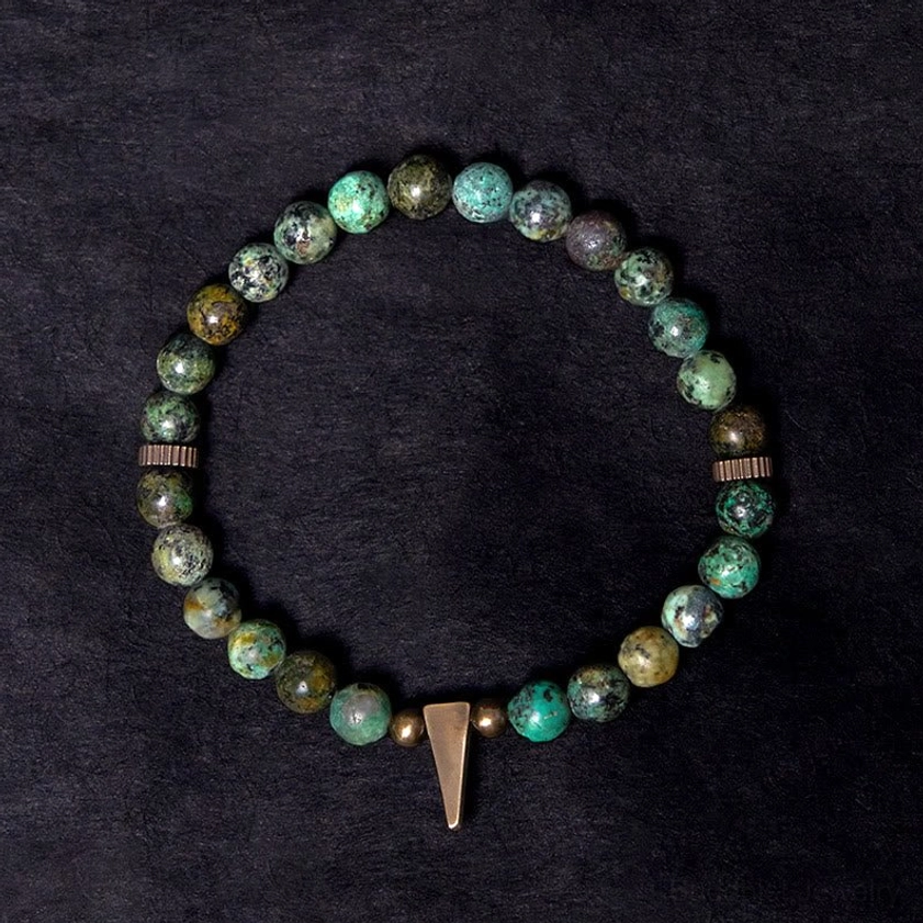 Detailed overhead view of turquoise copper bracelet showing tapered copper spike pendant and vintage metal spacers