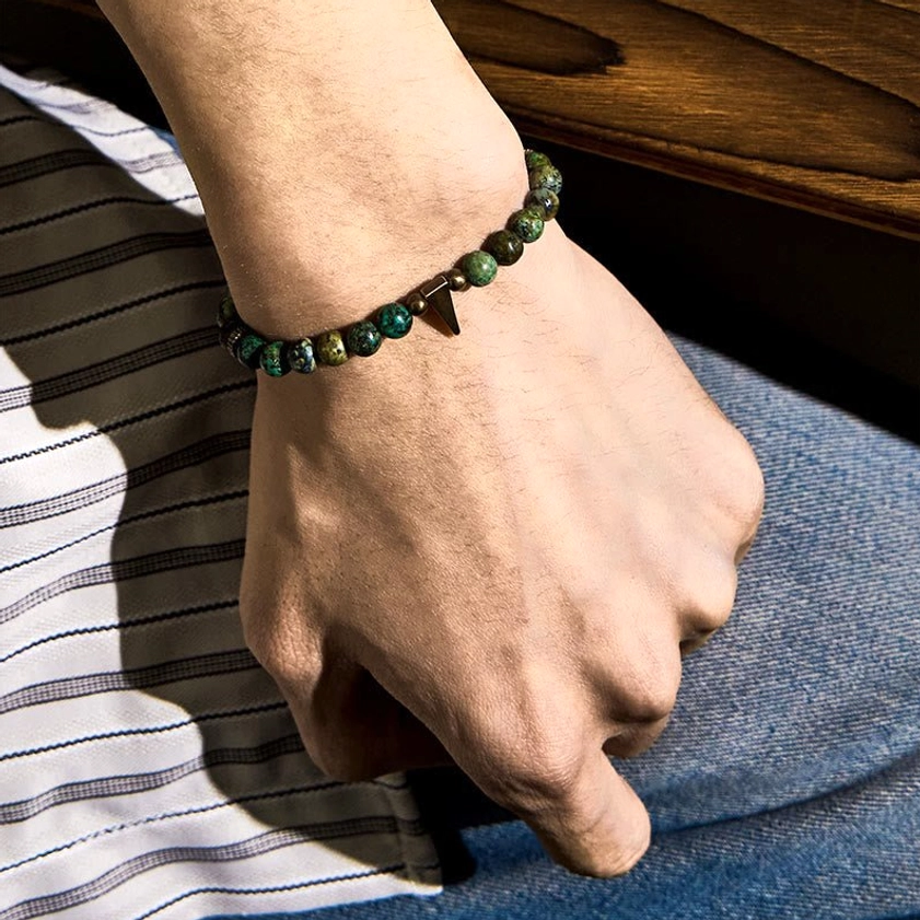 Turquoise copper spike bracelet worn on wrist with casual striped shirt and denim styling
