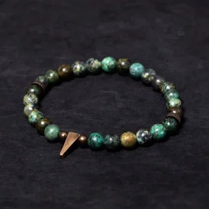 Turquoise copper spike bracelet with vintage antiqued copper charm and natural turquoise beads in overhead flat lay view