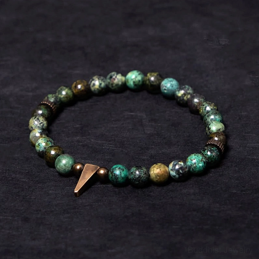 Turquoise copper spike bracelet with vintage antiqued copper charm and natural turquoise beads in overhead flat lay view