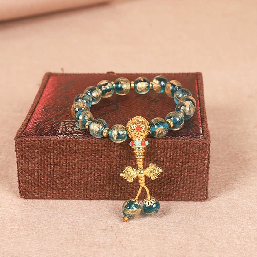 Turquoise Dorje Vajra Buddhist bracelet featuring turquoise semi-precious beads with gold enamel charm for protection and strength