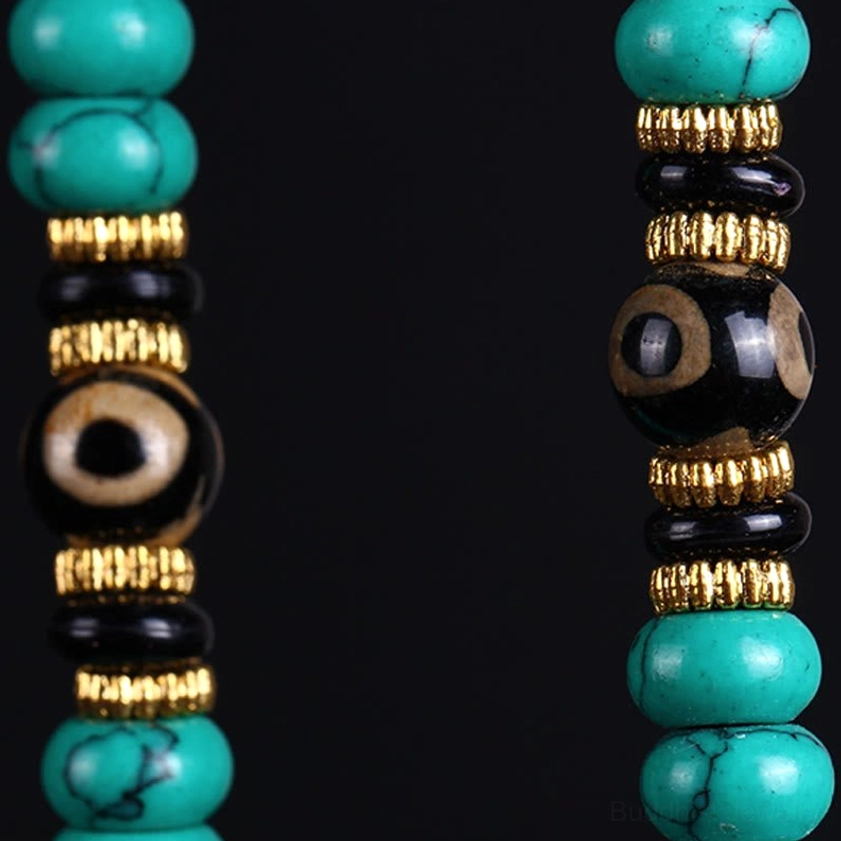 Close-up turquoise beads with black dzi eye and gold spacer ring detail