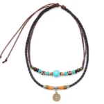 Turquoise Dzi bead Buddhist protection necklace with braided leather cord and antique coin pendant, flat lay overhead view
