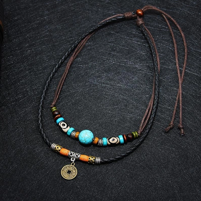 Two-strand turquoise Dzi bead Buddhist necklace with slip-knot closure and mixed ethnic accents, overhead flat lay