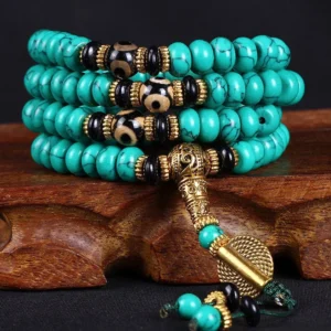 108 bead turquoise dzi Buddhist prayer mala on wooden stand with gold hardware detail
