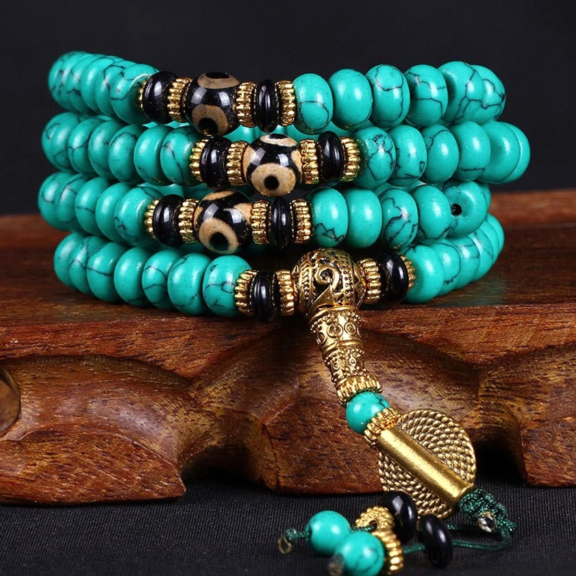 108 bead turquoise dzi Buddhist prayer mala on wooden stand with gold hardware detail