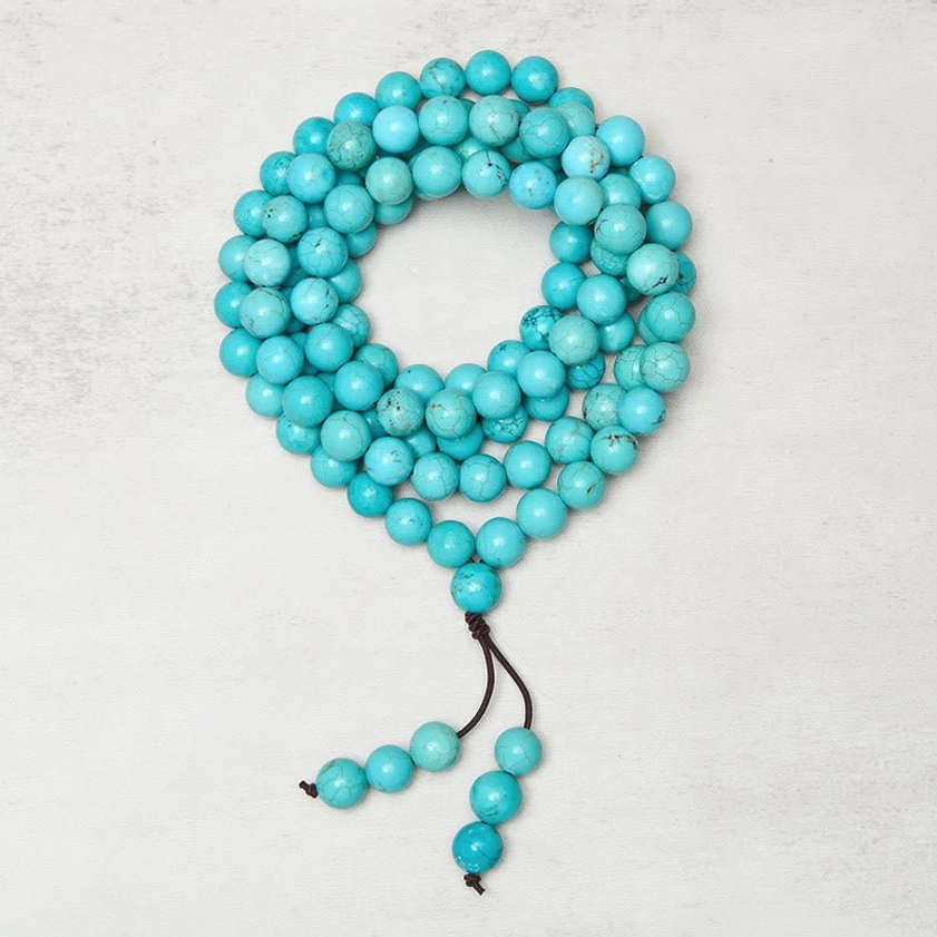 Coiled turquoise mala beads showing neat arrangement of 108 natural gemstone beads for spiritual practice