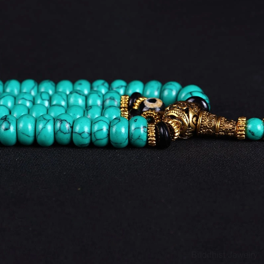 Turquoise mala prayer bead connector hardware with gold metal detail close-up