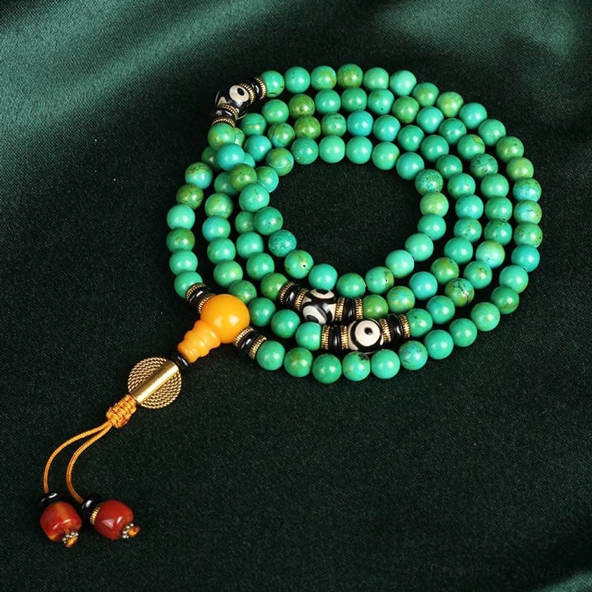 Full 108 bead turquoise Buddhist mala necklace loop with three-eye dzi cluster and red tassel agate charms flat lay