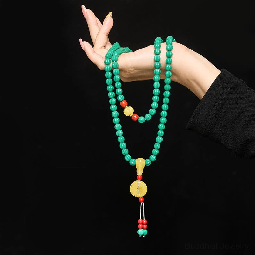 Multi-layer wrist wear style with turquoise Buddhist mala wrapped around wrist, close-up view on black background