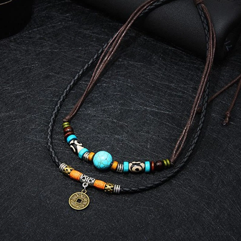 Adjustable turquoise Buddhist necklace with two-tone leather strands and copper coin pendant, overhead studio flat lay