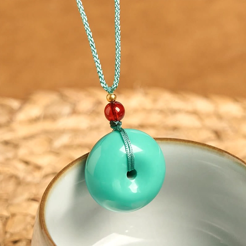 Turquoise Buddhist pendant with braided rope and gold spacer bead - side angle detail