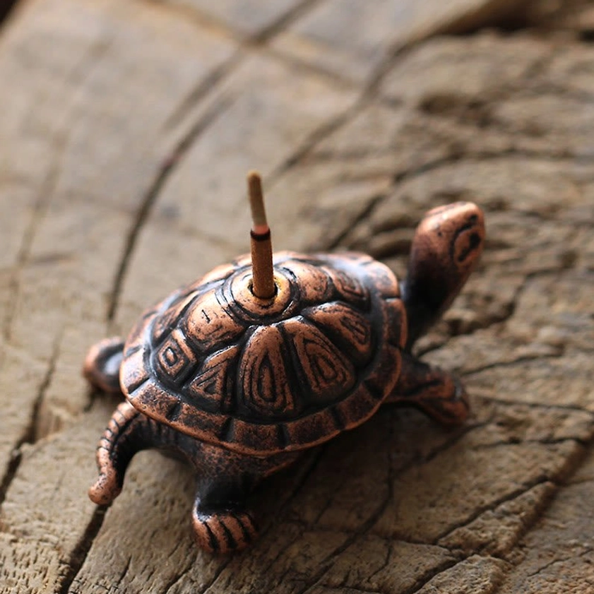 Bronze turtle incense burner rear overhead view showing detailed carapace carving on rustic wooden background