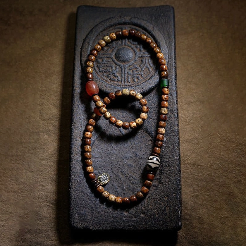Two handmade Buddhist prayer bead bracelets with bodhi seeds various agate beads on embossed stone tray display