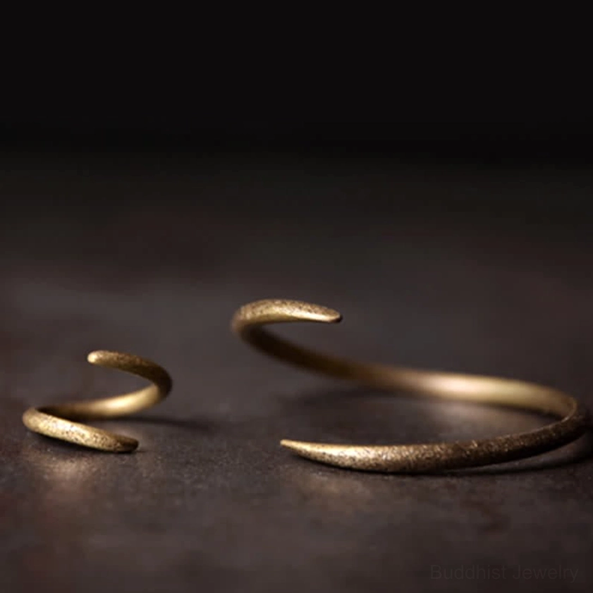Two adjustable copper cuff bracelets in different sizes with gold matte textured finish and hook ends