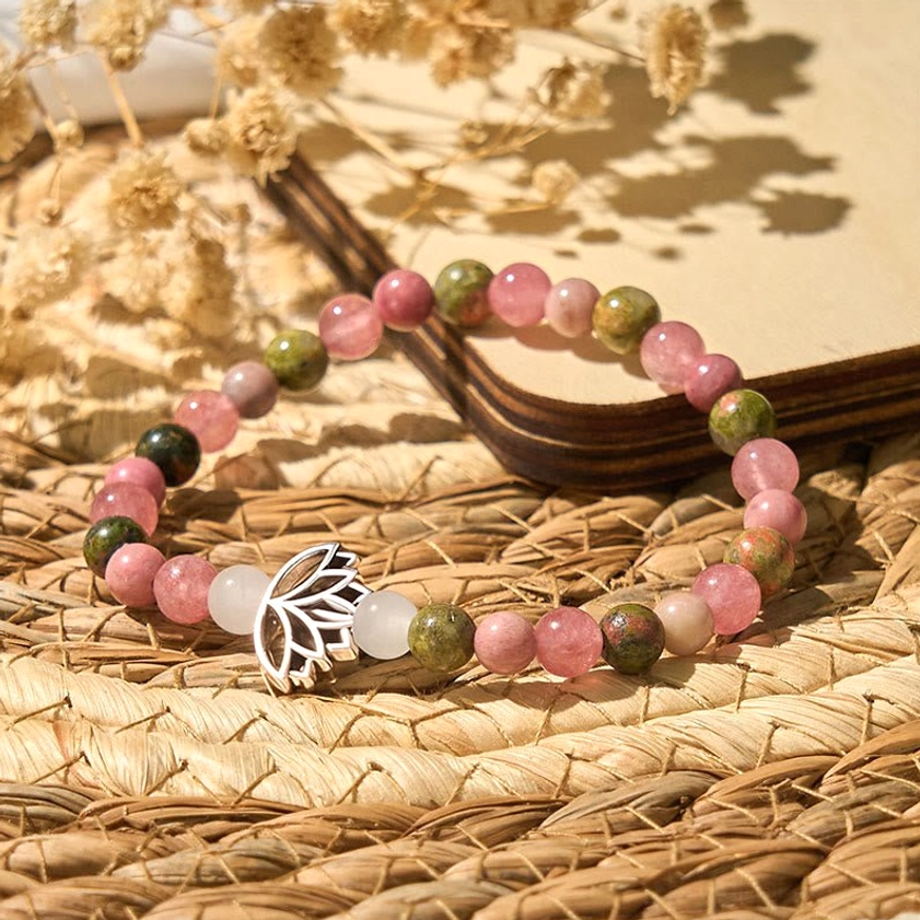 Buddhist healing bracelet with mixed stone beads and lotus accent on woven rattan mat