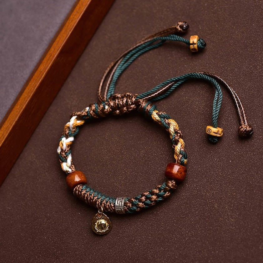 Unisex Buddhist string bracelet with adjustable fit, natural bone beads, woven rope, and protective spiritual pendant charm