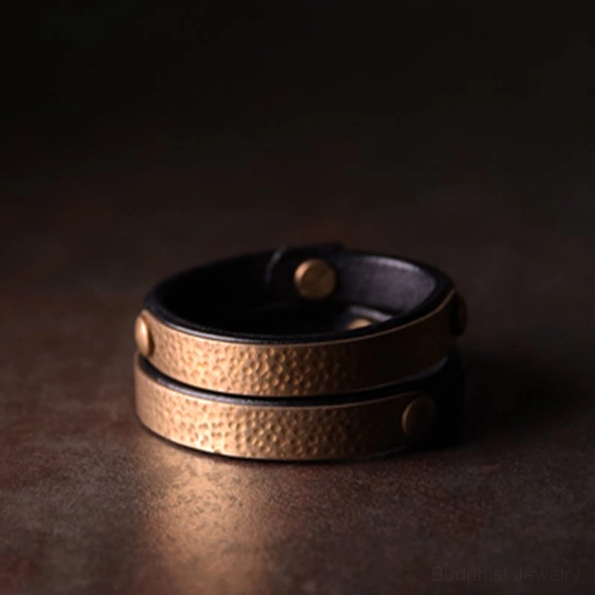 Unisex handcrafted copper leather bangle combining vintage aesthetic with Buddhist prosperity symbolism