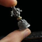 925 sterling silver vajra bell pendant with Om Mani Padme Hum engraving, side view showing aged silver patina and brass details
