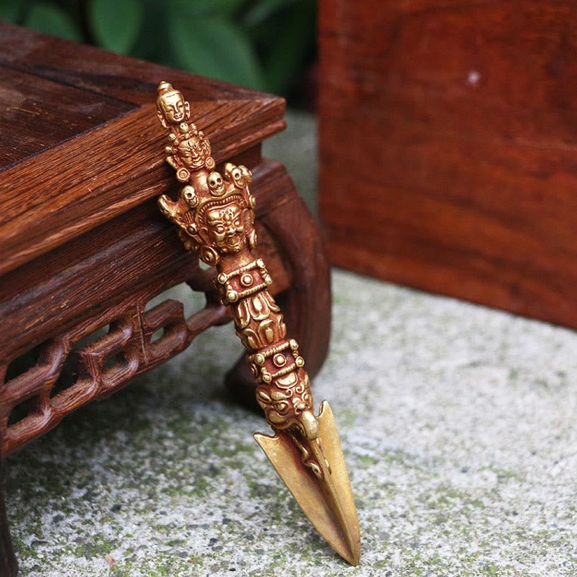 Authentic Nepal Vajra Dorje with ornate carved handle, right side view showcasing polished golden-bronze material and spiritual deity carvings