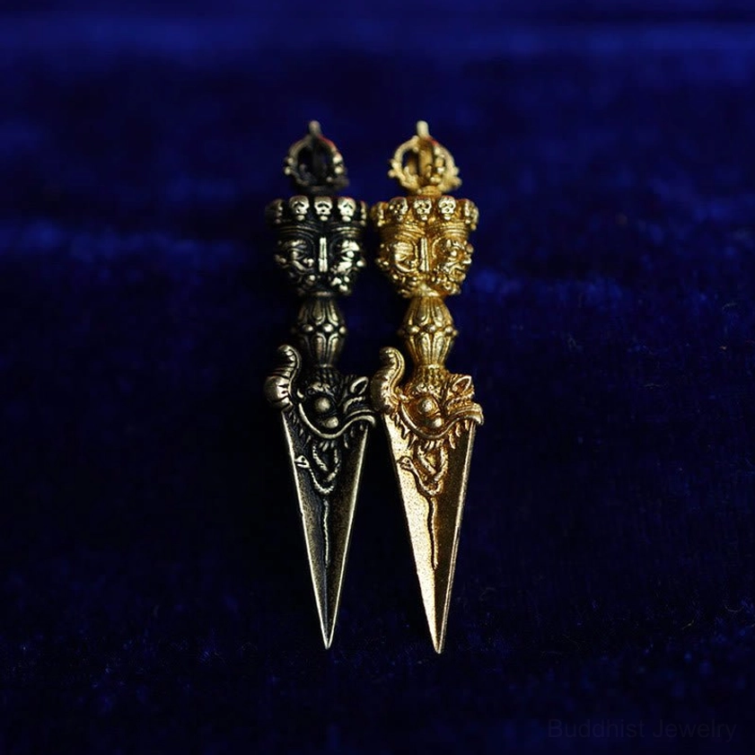 Comparison of two vajra dorje pendants in gold and antique bronze finishes side by side