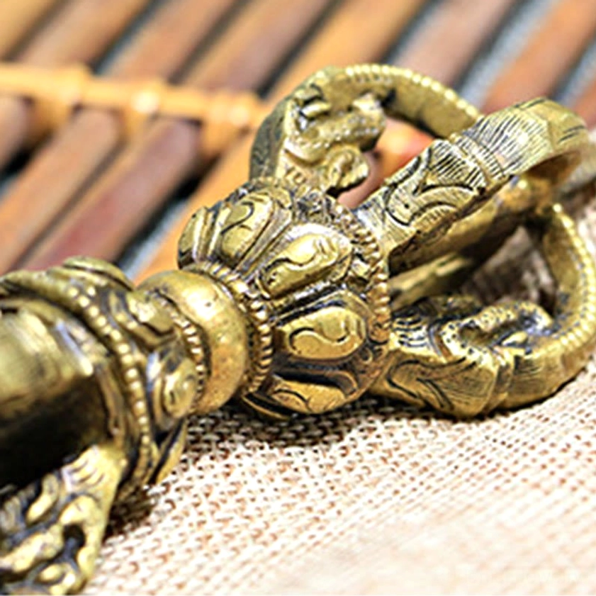 Macro side view of vajra dorje highlighting intricate religious carvings and antique bronze craftsmanship