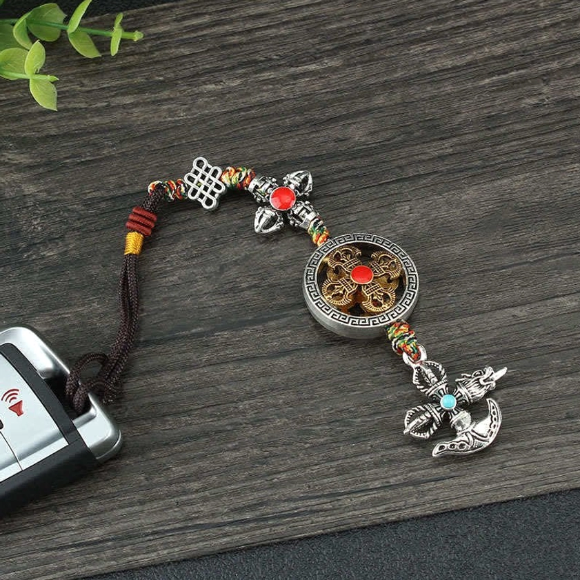 Buddhist vajra hanging ornament displayed with car key showing practical use as vehicle decoration