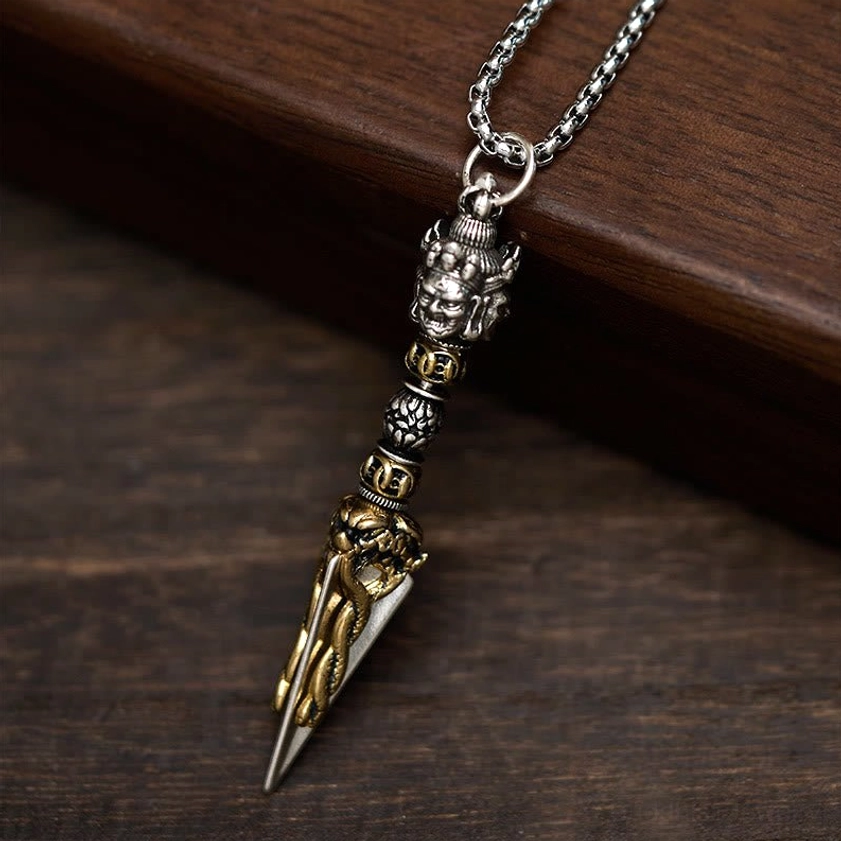 Vajrakila pendant necklace showing carved religious patterns and vintage metal finish on wheat-link chain