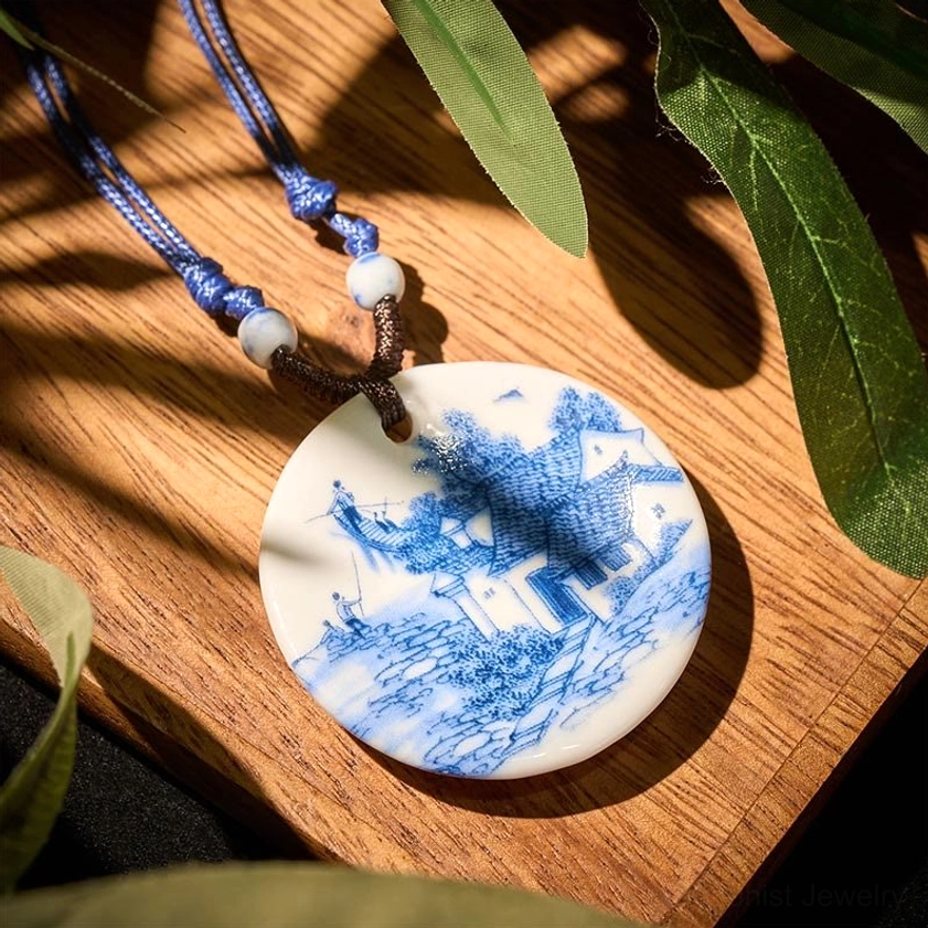 Village landscape ceramic pendant necklace overhead view on wooden table with natural styling