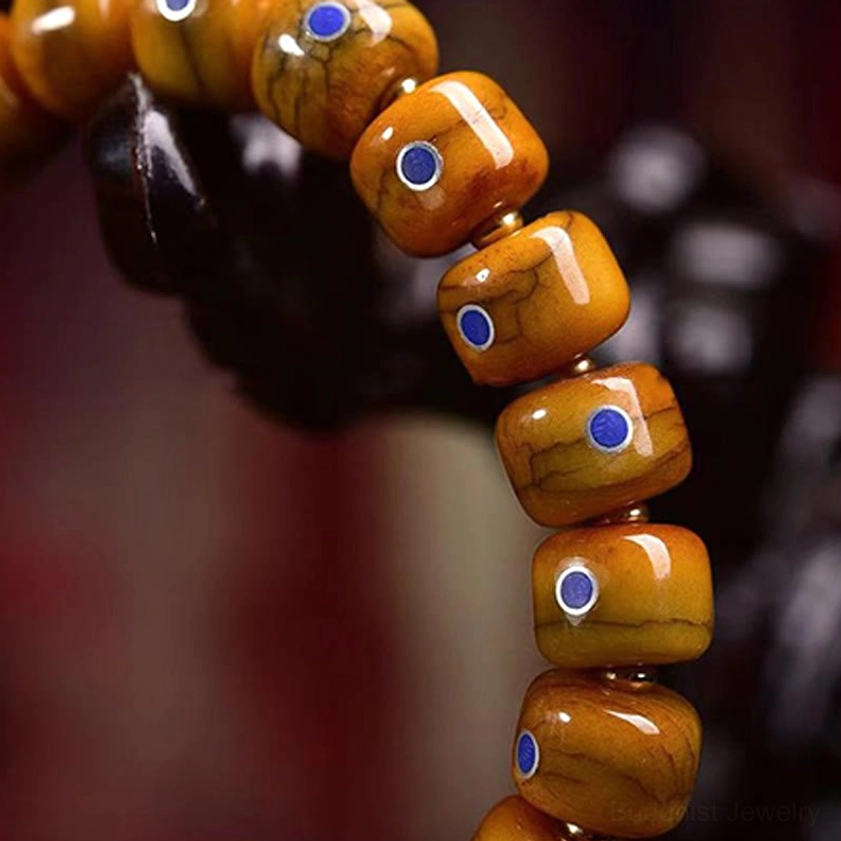 Magnified view of cracked vintage bone beads with circular lapis lazuli stone insets