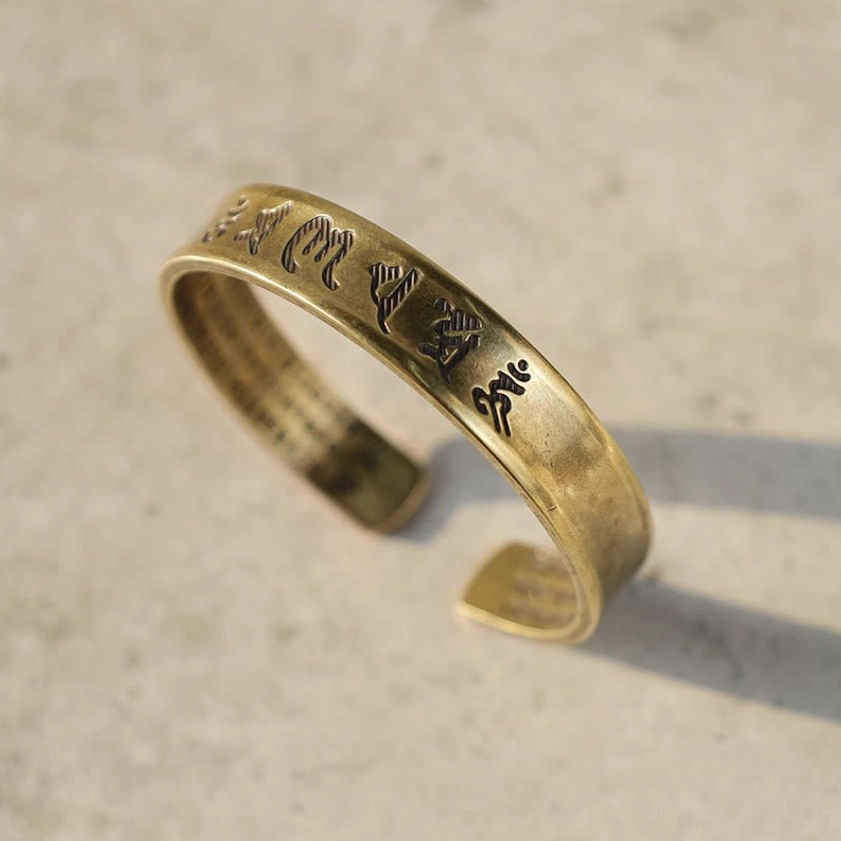 Tibetan Buddhist mantra brass cuff with vintage finish, engraved Sanskrit script on open-ended bracelet