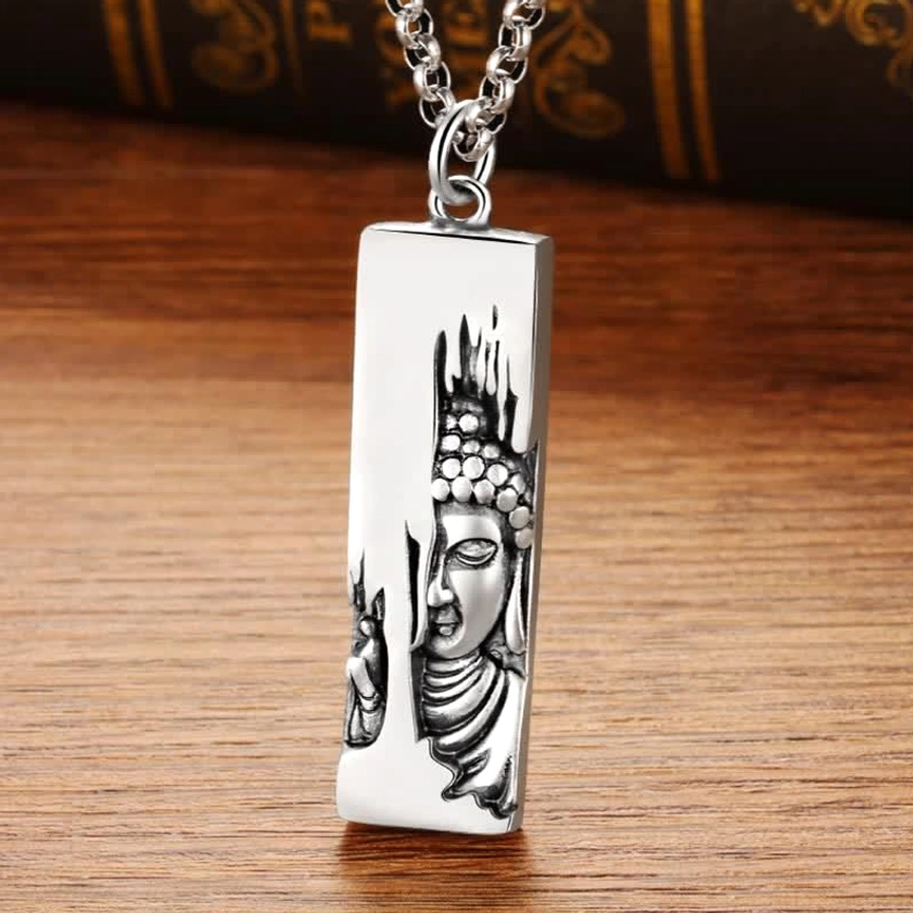 Vintage copper Buddha pendant necklace flat lay on wooden desk - detailed view of engraved Buddha relief and chain