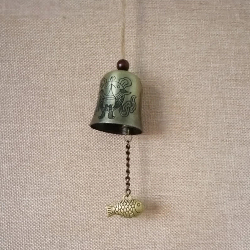 Vintage antique bronze Buddhist wind chime bell with traditional carved motifs and patina