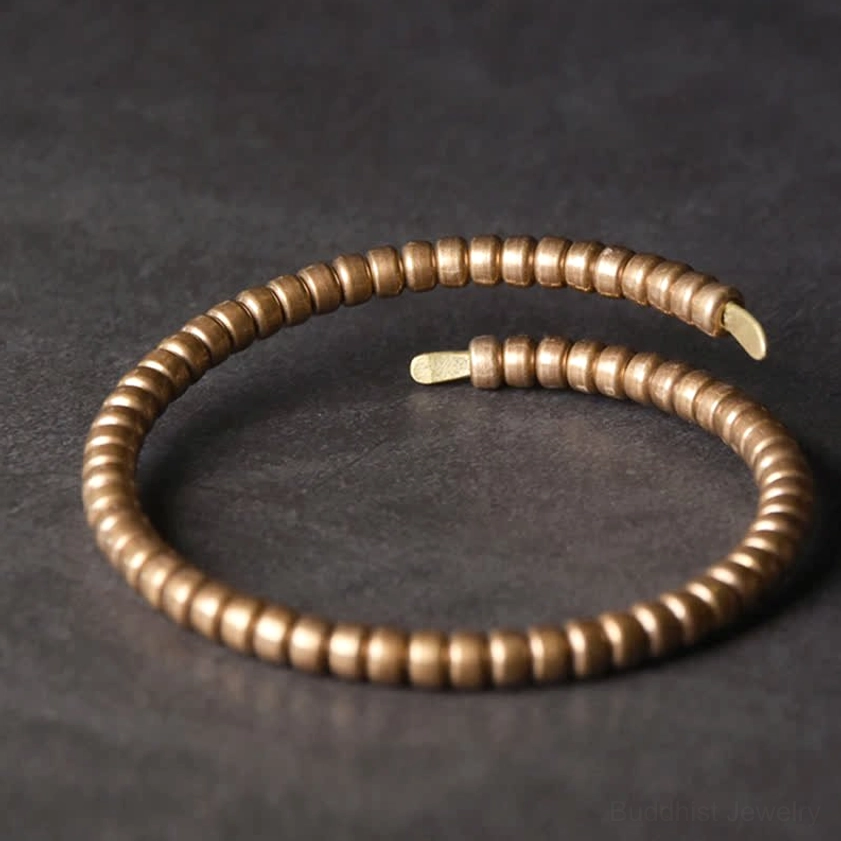 Vintage copper balance adjustable cuff bracelet with disk beads, flat lay top view on grey background