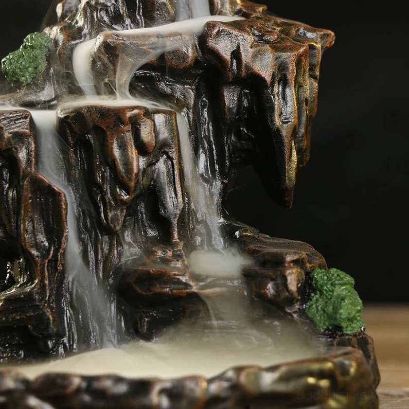 Mountain backflow incense burner side close-up, handcrafted resin with bronze-brown texture, moss accents, flowing incense smoke