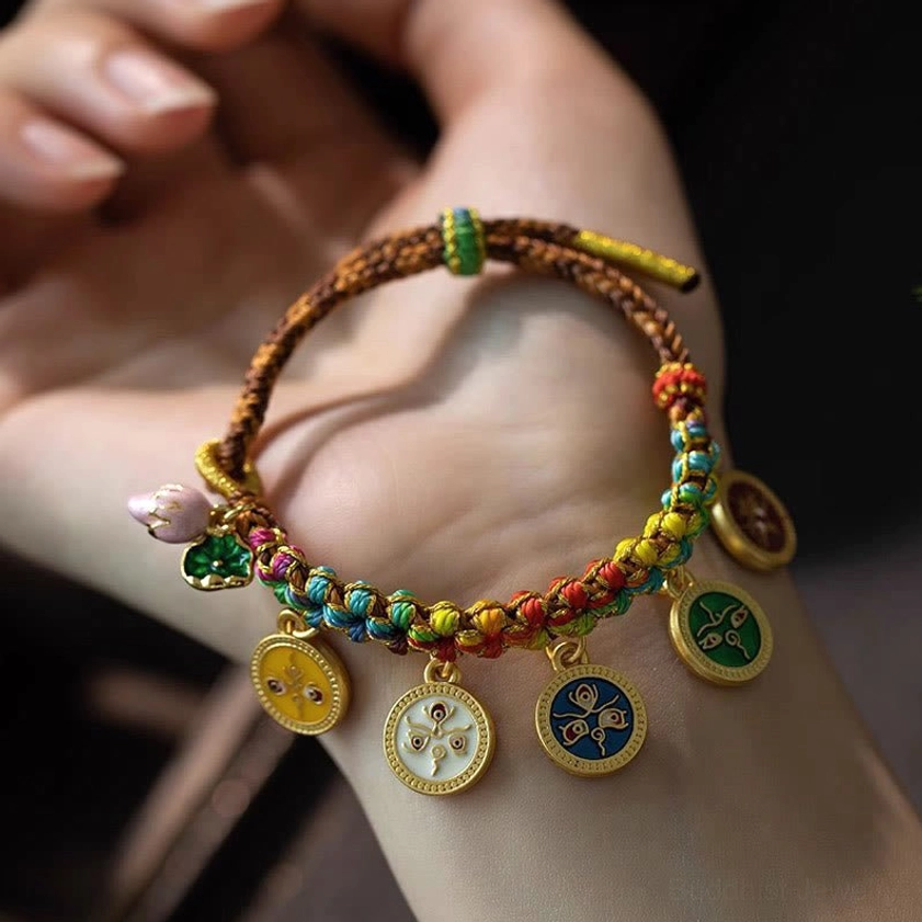 Adjustable five gods of wealth bracelet displayed on palm, showing braided cord structure and round enamel pendants with colorful accents