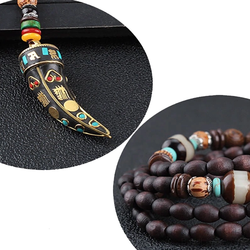 Close-up of wenge wood horn pendant with engraved sacred symbols and gold trim