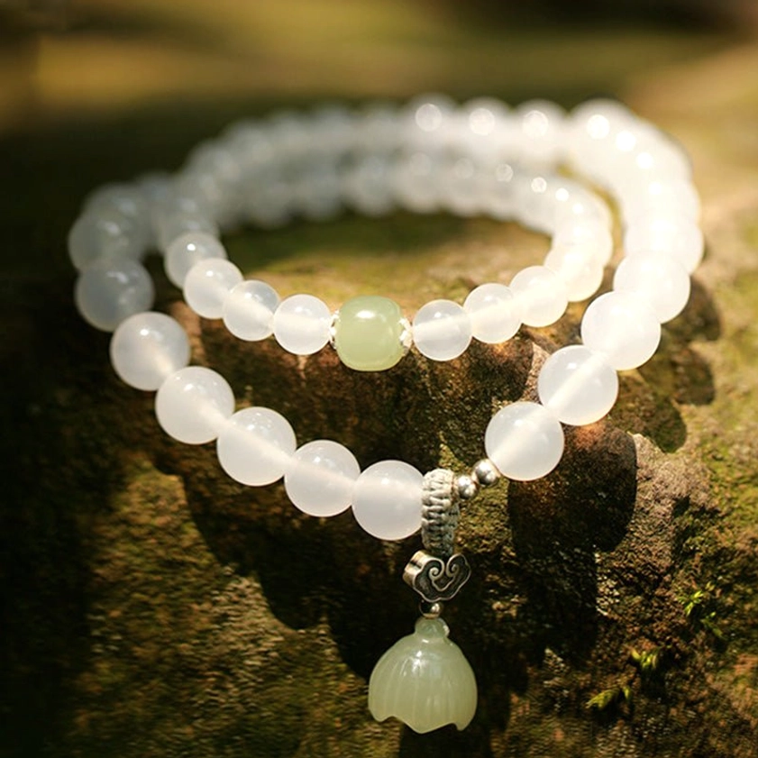 Frosted white agate double-wrap bracelet with pale green spacer and carved green lotus pendant on mossy stone