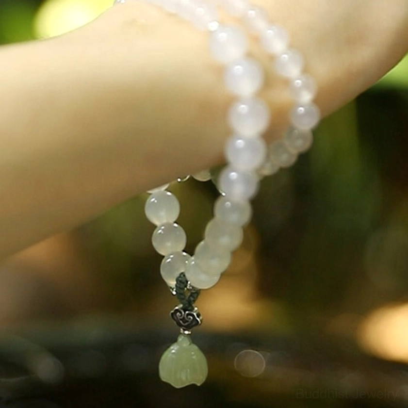 Frosted white agate beads with silver wishbone clasp and dangling green jade lotus pendant close-up