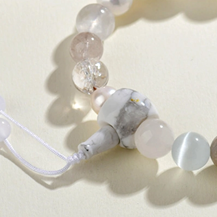 Close-up macro view of white agate pearl bracelet beads showing guru bead and crystal detail