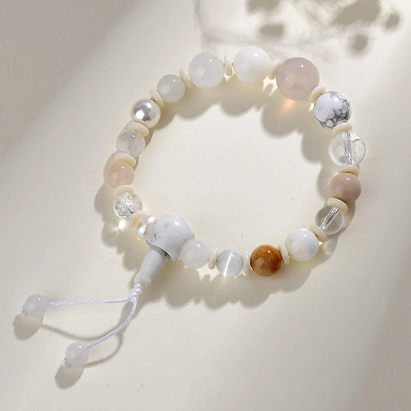 White agate pearl bracelet side view with mixed gemstone beads and tassel closure on neutral background