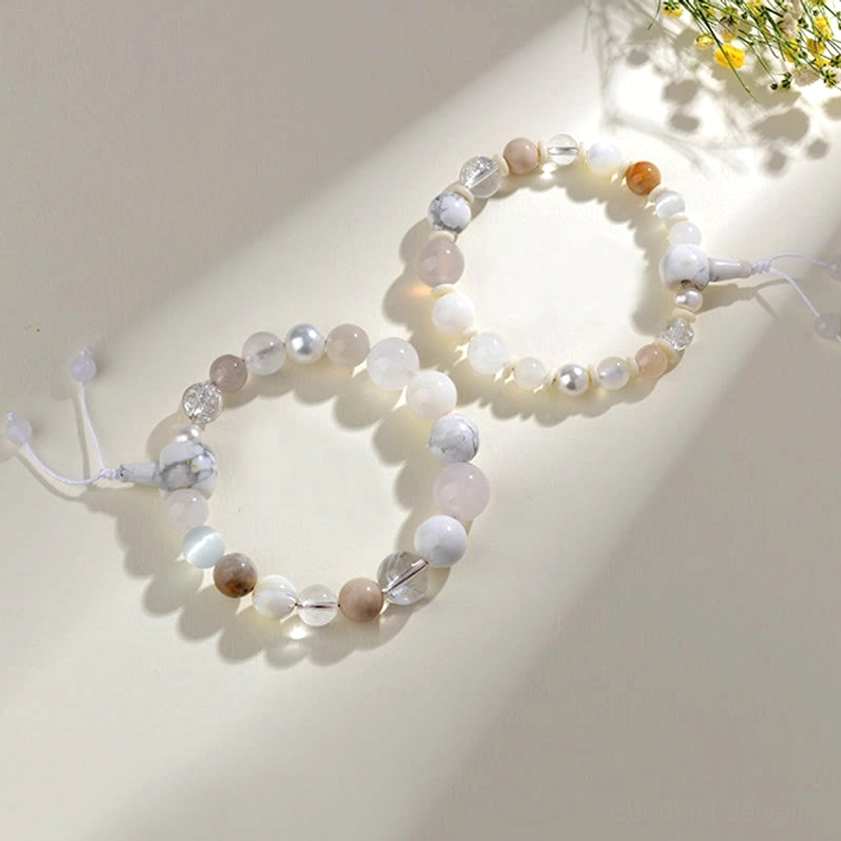 Macro close-up of two white agate pearl bracelets showing faceted bead detail and warm neutral tones