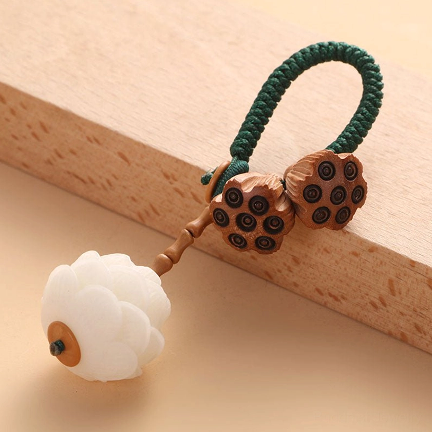 Buddhist lotus keychain featuring white bodhi seeds and wooden lotus pods with green braided cord